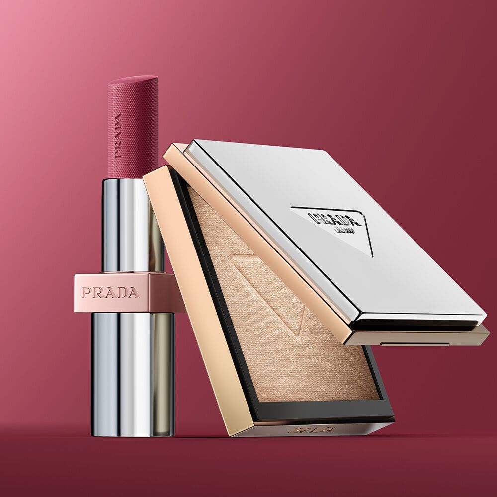 Verlee (blonde model) is wearing Prada Light Glowing Lipcolor Rosewood and Glowing Powder Champagne on a pink background.